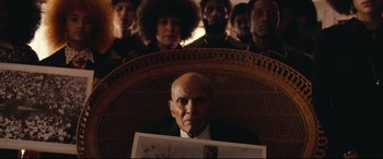 Movie still from “BlacKkKlansman” (2018), directed by Spike Lee – An old man sitting in front of a group of people; Medium shot, High angle