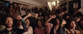 Movie still from “BlacKkKlansman” (2018), directed by Spike Lee – A group of people with their hands raised in the air; Medium shot, High angle