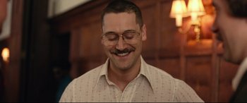 Movie still from “BlacKkKlansman” (2018), directed by Spike Lee – A person wearing glasses and smiling; Close Up shot, Low angle