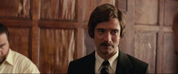 Movie still from “BlacKkKlansman” (2018), directed by Spike Lee – A person wearing a suit and tie; Close Up shot, Over the shoulder angle