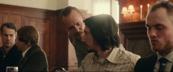 Movie still from “BlacKkKlansman” (2018), directed by Spike Lee – A man standing next to another man in a room; Medium shot, Over the shoulder angle