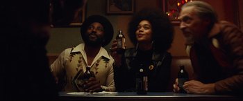 Movie still from “BlacKkKlansman” (2018), directed by Spike Lee – A man and a woman sitting at a table; Medium shot, Low angle
