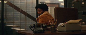 Movie still from “BlacKkKlansman” (2018), directed by Spike Lee – A man sitting at a desk in front of a window; Medium shot, Over the shoulder angle