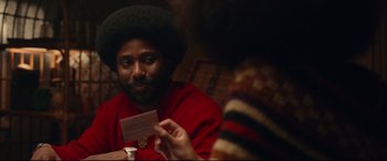Movie still from “BlacKkKlansman” (2018), directed by Spike Lee – A man in a red shirt is holding a piece of paper; Close Up shot, Over the shoulder angle