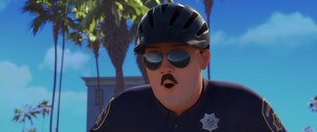 Movie still from “Scoob!” (2020), directed by Tony Cervone – A man in a police uniform wearing sunglasses and a helmet; Close Up shot, Low angle