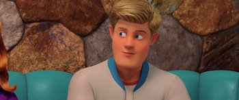 Movie still from “Scoob!” (2020), directed by Tony Cervone – A cartoon of a man with blue eyes looking at the camera; Close Up shot, Over the shoulder angle