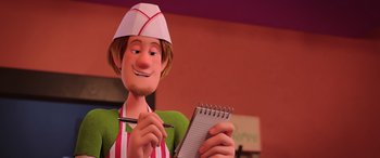 Movie still from “Scoob!” (2020), directed by Tony Cervone – An animated person holding a pen and a notebook; Close Up shot, Over the shoulder angle