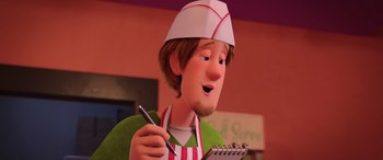 Movie still from “Scoob!” (2020), directed by Tony Cervone – A man in an apron holding a pen and a notebook; Close Up shot, High angle