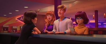 Movie still from “Scoob!” (2020), directed by Tony Cervone – A group of people sitting at a counter; Medium shot, Over the shoulder angle