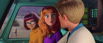 Movie still from “Scoob!” (2020), directed by Tony Cervone – A group of people standing next to each other in a car; Medium shot, Over the shoulder angle