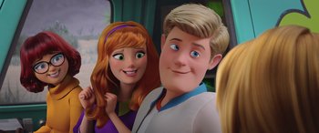 Movie still from “Scoob!” (2020), directed by Tony Cervone – A couple of people that are posing for a picture; Close Up shot, Over the shoulder angle