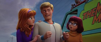 Movie still from “Scoob!” (2020), directed by Tony Cervone – A man standing next to a woman and a girl; Medium shot, Over the shoulder angle