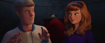 Movie still from “Scoob!” (2020), directed by Tony Cervone – A man and a woman standing next to each other in a room; Close Up shot, Over the shoulder angle