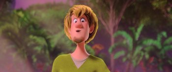 Movie still from “Scoob!” (2020), directed by Tony Cervone – A cartoon of a man with blonde hair and a green shirt; Close Up shot, Over the shoulder angle