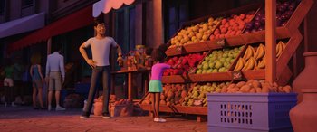 Movie still from “Scoob!” (2020), directed by Tony Cervone – An animated scene of a man and a little girl looking at a display of fruit; Wide shot, Over the shoulder angle
