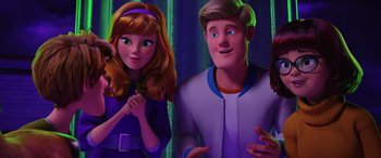 Movie still from “Scoob!” (2020), directed by Tony Cervone – A man and a woman standing next to each other; Medium shot, Low angle