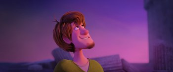 Movie still from “Scoob!” (2020), directed by Tony Cervone – A man with long hair is looking up at the sky; Medium shot, Low angle