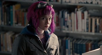 Movie still from “Scott Pilgrim vs. the World” (2010), directed by Edgar Wright – A woman with pink hair and glasses in front of a book shelf; Close Up shot, Over the shoulder angle