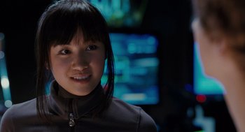 Movie still from “Scott Pilgrim vs. the World” (2010), directed by Edgar Wright – A young woman smiles for the camera in front of a television; Close Up shot, Over the shoulder angle