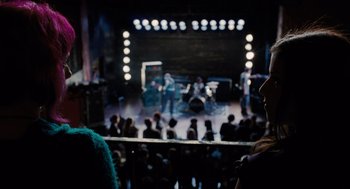 Movie still from “Scott Pilgrim vs. the World” (2010), directed by Edgar Wright – A group of people watching a band perform on a stage; Wide shot, Over the shoulder angle