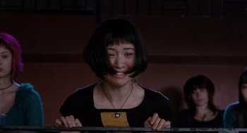 Movie still from “Scott Pilgrim vs. the World” (2010), directed by Edgar Wright – A woman with short black hair is smiling for the camera; Close Up shot, Low angle