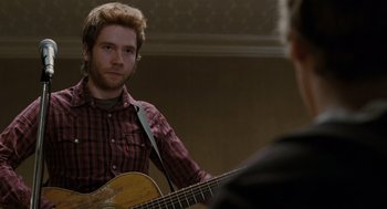 Movie still from “Scott Pilgrim vs. the World” (2010), directed by Edgar Wright – A man holding a guitar in front of another man; Close Up shot, Over the shoulder angle
