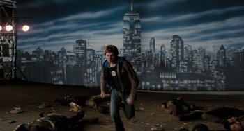 Movie still from “Scott Pilgrim vs. the World” (2010), directed by Edgar Wright – A young man is walking in front of an image of a city skyline; Wide shot, High angle