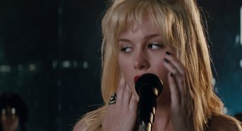 Movie still from “Scott Pilgrim vs. the World” (2010), directed by Edgar Wright – A woman with her hand on her face while holding a microphone; Close Up shot, Over the shoulder angle