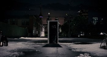 Movie still from “Scott Pilgrim vs. the World” (2010), directed by Edgar Wright – Two people are standing in the doorway of a building at night; Extreme Wide shot, High angle