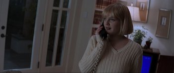 Movie still from “Scream” (1996), directed by Wes Craven – A young woman talking on a phone while wearing a sweater; Medium shot, High angle