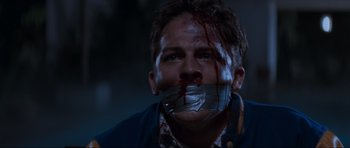Movie still from “Scream” (1996), directed by Wes Craven – A man with duct tape over his mouth and face; Close Up shot, Low angle