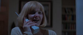 Movie still from “Scream” (1996), directed by Wes Craven – A woman holding a cell phone to her ear; Close Up shot, Low angle