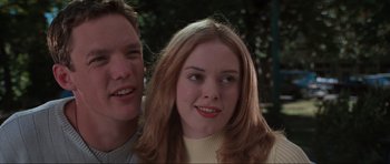 Movie still from “Scream” (1996), directed by Wes Craven – A young man and a young woman smiling for the camera; Close Up shot, Low angle