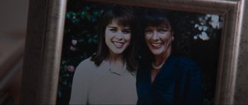Movie still from “Scream” (1996), directed by Wes Craven – Two women smile for a picture together; Extreme Close Up shot, Overhead angle