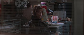Movie still from “Scream” (1996), directed by Wes Craven – A woman sitting in front of a computer desk; Medium shot, Over the shoulder angle