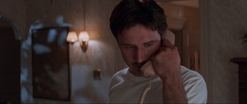 Movie still from “Scream” (1996), directed by Wes Craven – A man holding a phone up to his ear; Close Up shot, Low angle