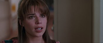 Movie still from “Scream” (1996), directed by Wes Craven – A woman's face in a dark room; Close Up shot, Over the shoulder angle