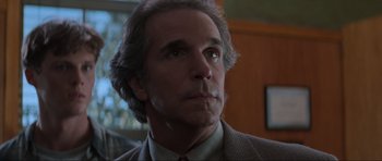 Movie still from “Scream” (1996), directed by Wes Craven – A person wearing a suit and tie; Close Up shot, Low angle