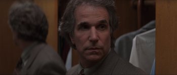 Movie still from “Scream” (1996), directed by Wes Craven – An older man in a suit and tie looking to his left; Close Up shot, Over the shoulder angle