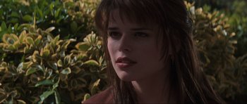 Movie still from “Scream” (1996), directed by Wes Craven – A person wearing a red shirt near a bush; Close Up shot, Over the shoulder angle