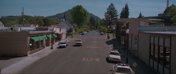 Movie still from “Scream” (1996), directed by Wes Craven – Police cars are parked on the side of the street; Extreme Wide shot, High angle