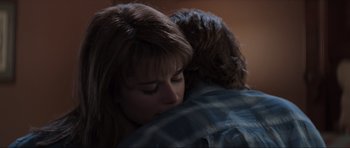 Movie still from “Scream” (1996), directed by Wes Craven – A woman is hugging a man in a room; Close Up shot, Over the shoulder angle