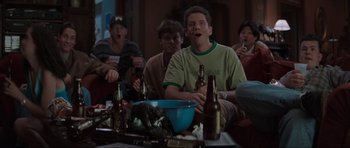 Movie still from “Scream” (1996), directed by Wes Craven – A group of people sitting around a table with beer; Medium shot, Low angle