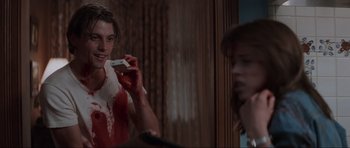 Movie still from “Scream” (1996), directed by Wes Craven – A young man brushing his teeth in front of a mirror; Medium shot, Over the shoulder angle