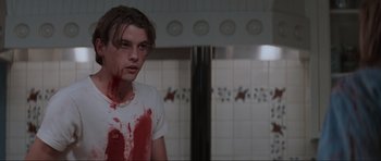 Movie still from “Scream” (1996), directed by Wes Craven – A man with blood all over his face; Medium shot, Low angle