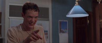Movie still from “Scream” (1996), directed by Wes Craven – A man is smiling and making a funny face; Close Up shot, Low angle