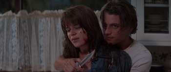 Movie still from “Scream” (1996), directed by Wes Craven – A woman holding a knife with blood all over her face; Close Up shot, Low angle