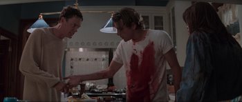 Movie still from “Scream” (1996), directed by Wes Craven – Two men are shaking hands in a kitchen; Medium shot, Over the shoulder angle