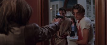 Movie still from “Scream” (1996), directed by Wes Craven – A man holding a gun in front of a mirror; Medium shot, Over the shoulder angle