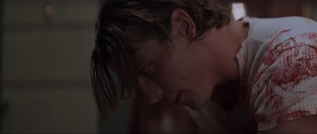 Movie still from “Scream” (1996), directed by Wes Craven – A man's face in a dark room; Close Up shot, Low angle